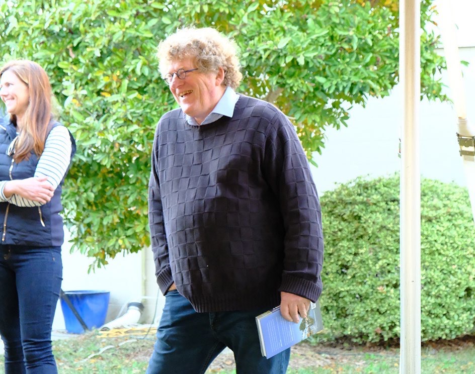 A man smiles as he walks through Chatham Vineyards