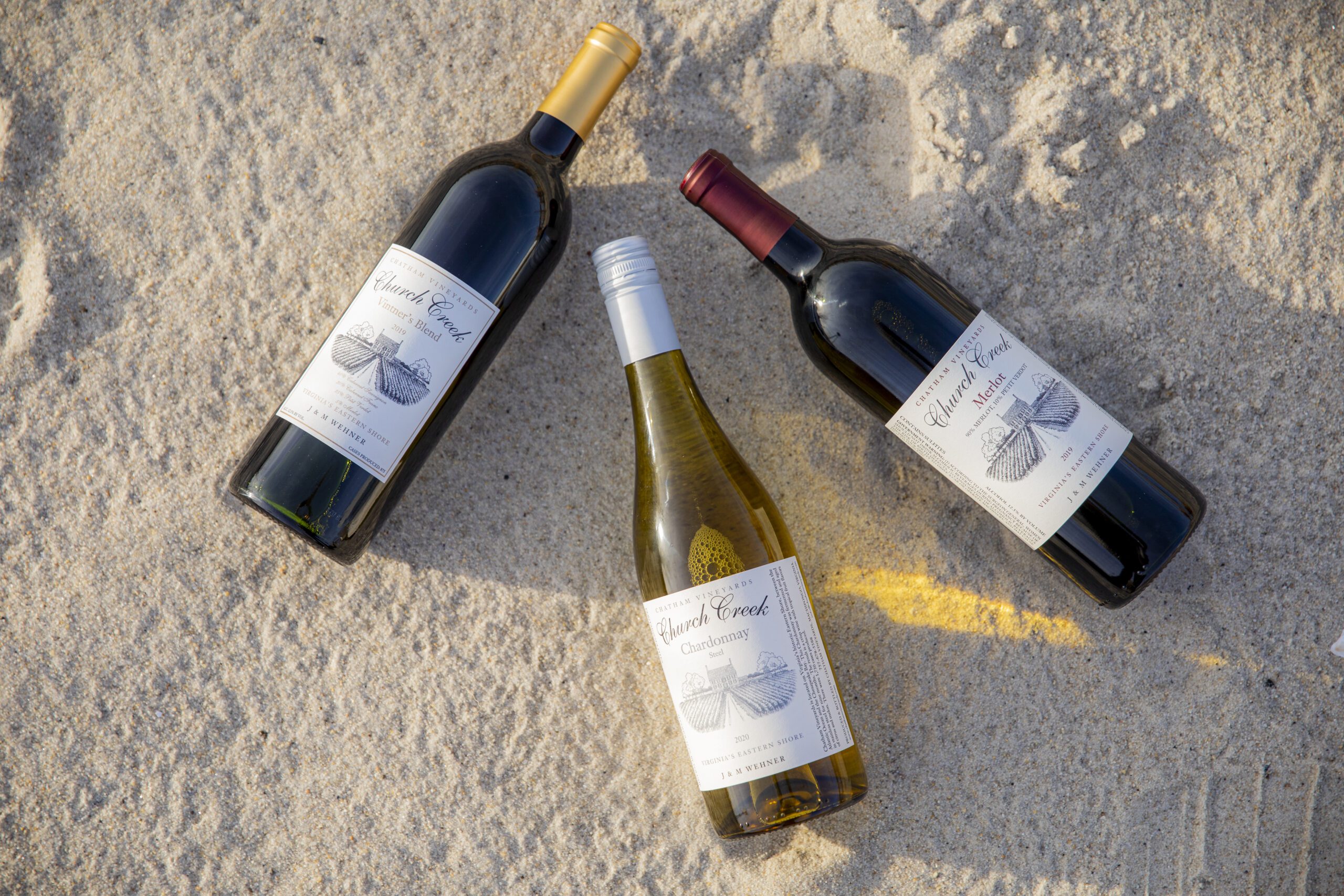 Three Chatham Vineyards wine bottles on the sand